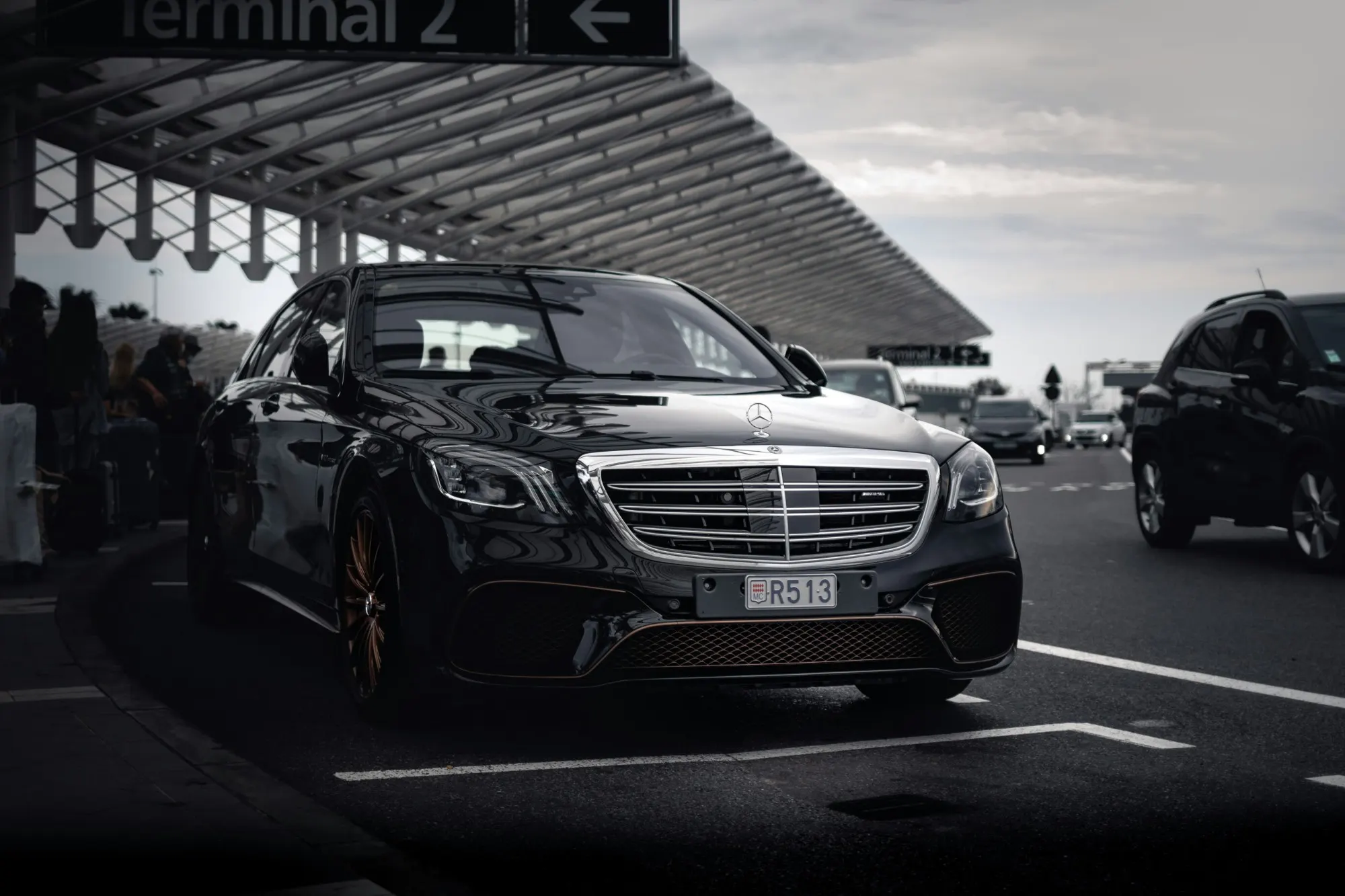 A black executive saloon waiting at an airport terminal kerbside